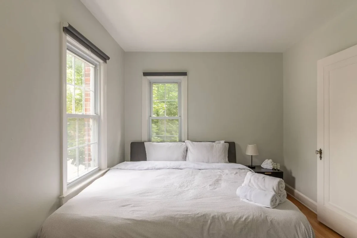 Burns Park home bedroom with white bedding and two windows